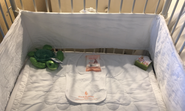 a baby bib and toys on a crib