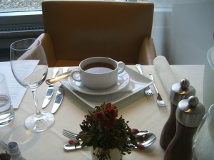 a cup of coffee on a plate with a flower on a table