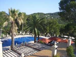 a swimming pool with palm trees and umbrellas