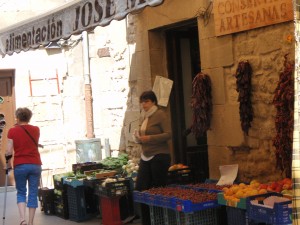 a woman standing outside a fruit stand