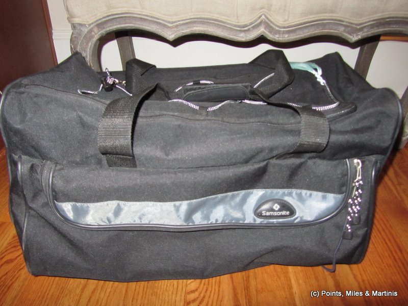 a black duffel bag on a wood floor