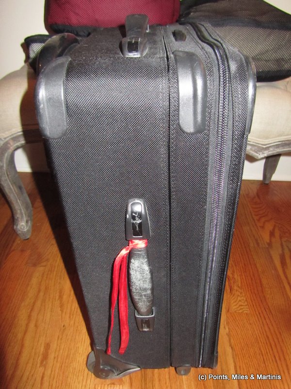 a black suitcase with a red ribbon