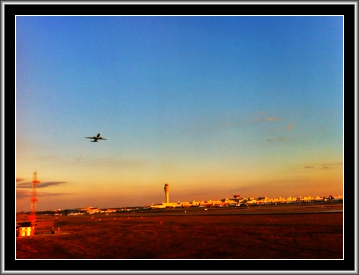 an airplane flying over a runway