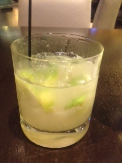 a glass of liquid with ice and limes