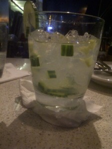a glass of water with cucumber slices