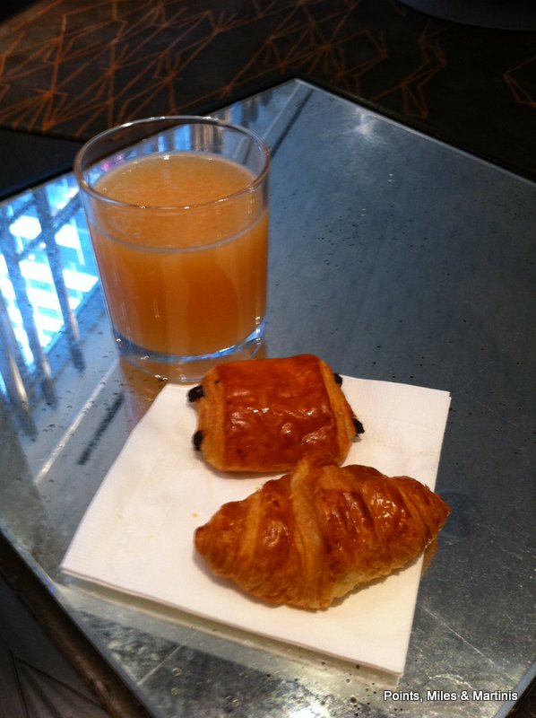 a glass of juice next to pastries