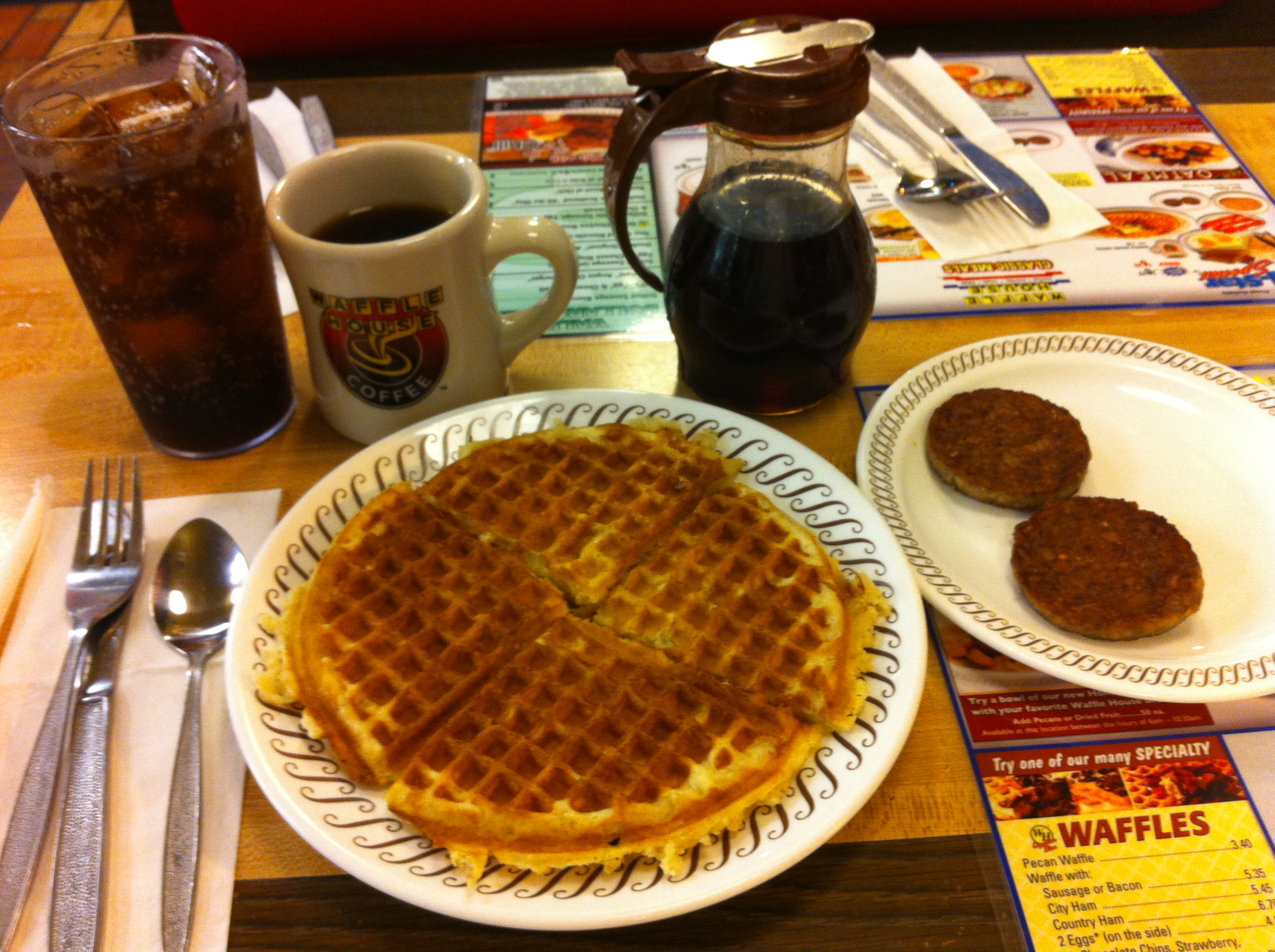a waffles on a plate with a drink and a mug of coffee