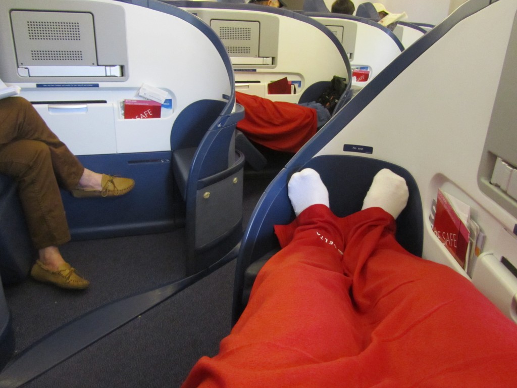 a person's legs in a red blanket on an airplane