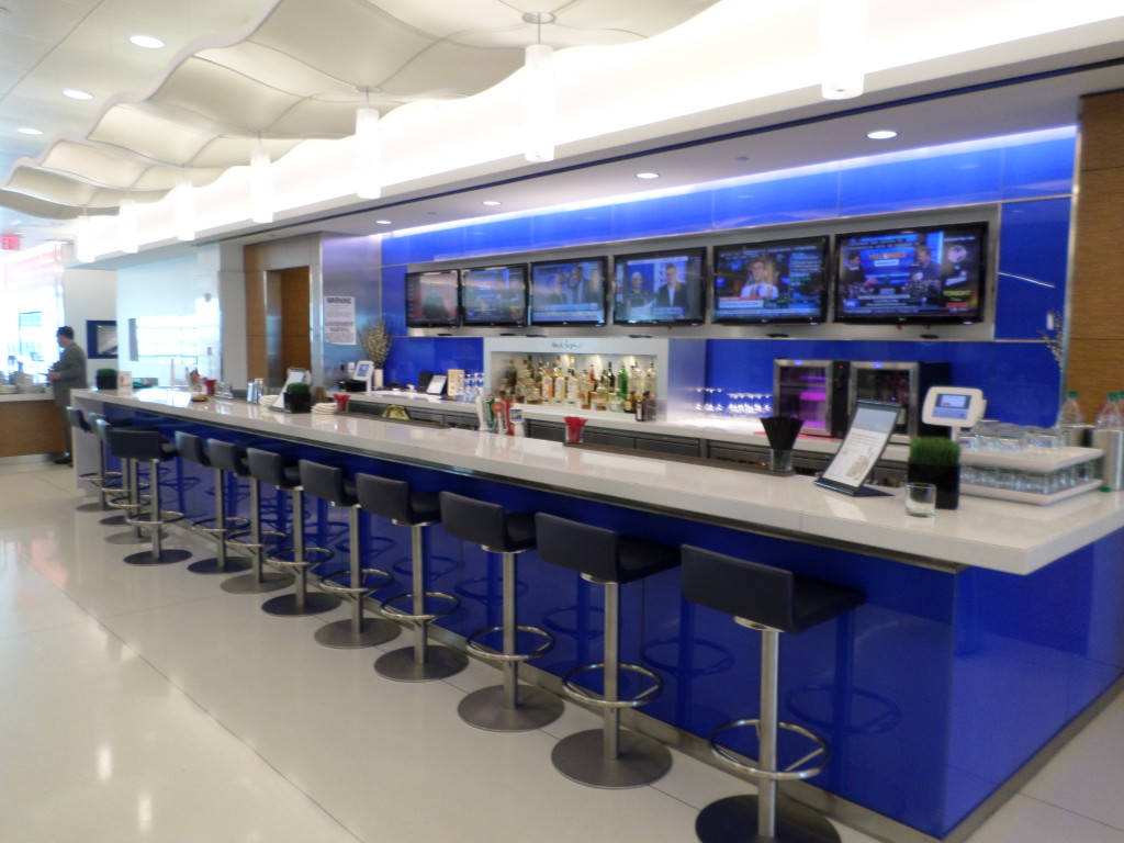 a bar with blue bar stools and tvs