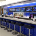 a bar with blue bar stools and tvs