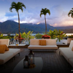 a patio with white couches and palm trees