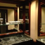 a bathroom with a marble countertop and a glass shelf