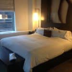 a bed with white sheets and pillows