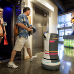 a man walking next to a robot