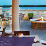 a fire pit with a table and chairs on a patio