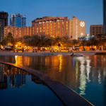 a building with many lights on it and a body of water