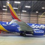 a blue and red airplane in a hangar