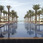 a pool with palm trees and a beach