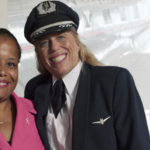 a man in a uniform smiling with a woman in the background