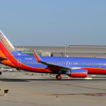 a blue and red airplane on a runway