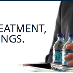 a man holding a tray of water bottles