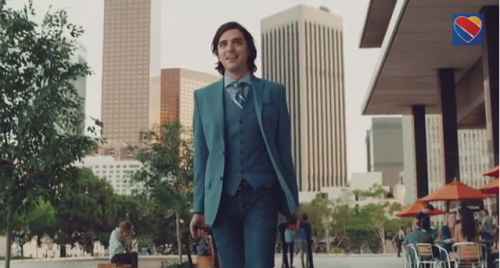 a man in a suit and tie holding luggage