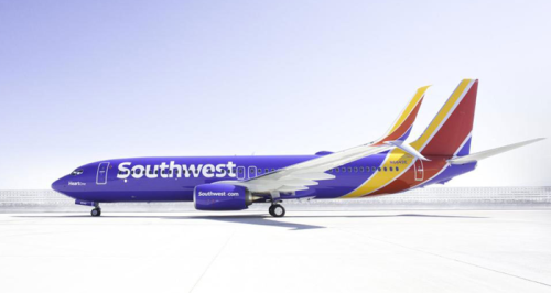 a blue and yellow airplane on a runway