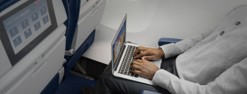 a man using a laptop on an airplane