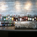 a group of bottles of alcohol on a bar