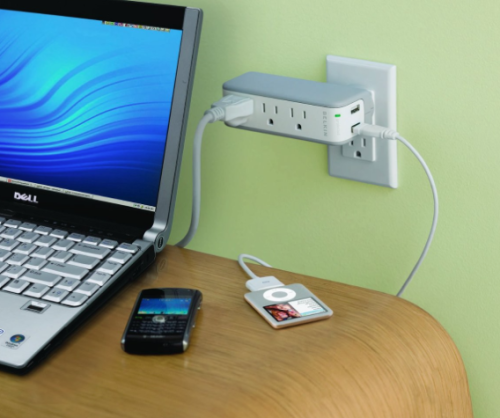 a laptop and cell phone plugged into a power outlet