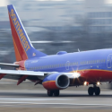 a blue and red airplane on a runway