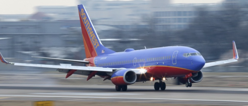 a blue and red airplane on a runway