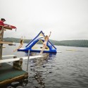 a group of people jumping into a lake