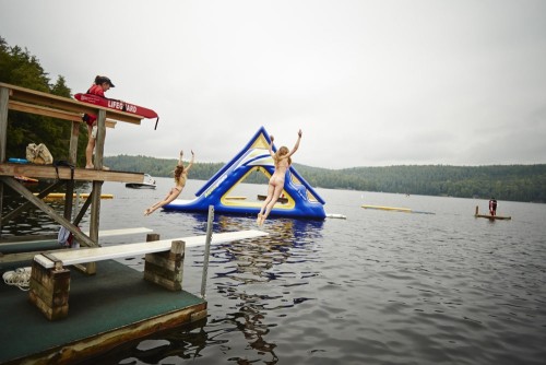 a group of people jumping into a lake