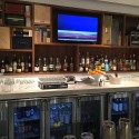 a bar with bottles of alcohol and a television