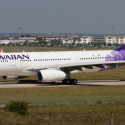 a white and purple airplane on a runway