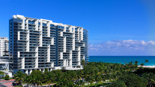 a large white building with many balconies and trees