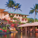 a building with a thatched roof and palm trees