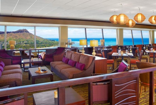 a room with a view of the ocean and a mountain