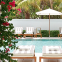 a pool with lounge chairs and umbrellas