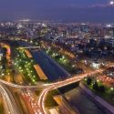 a city at night with a river and a bridge