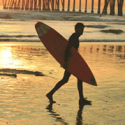 a man carrying a surfboard on a beach