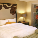 a bed with a large headboard in a hotel room