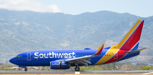 a blue and yellow airplane on a runway