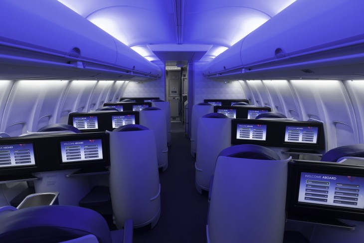 an inside of an airplane with rows of monitors