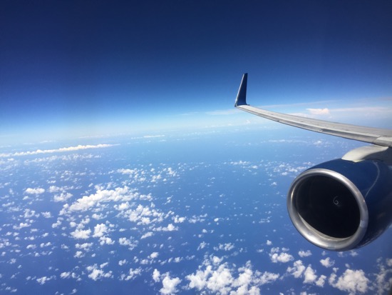 an airplane wing and blue sky