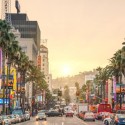 a busy street with palm trees and buildings