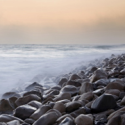 a rocky beach with waves crashing on it