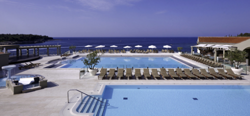 a pool with chairs and umbrellas