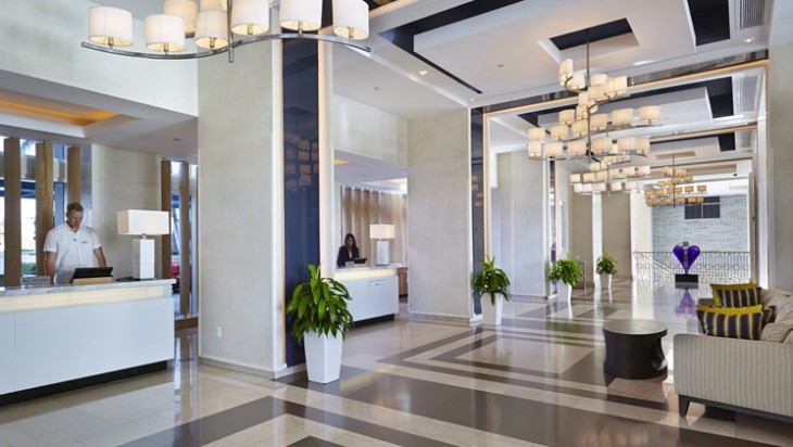 a lobby with a checkered floor and a woman behind it